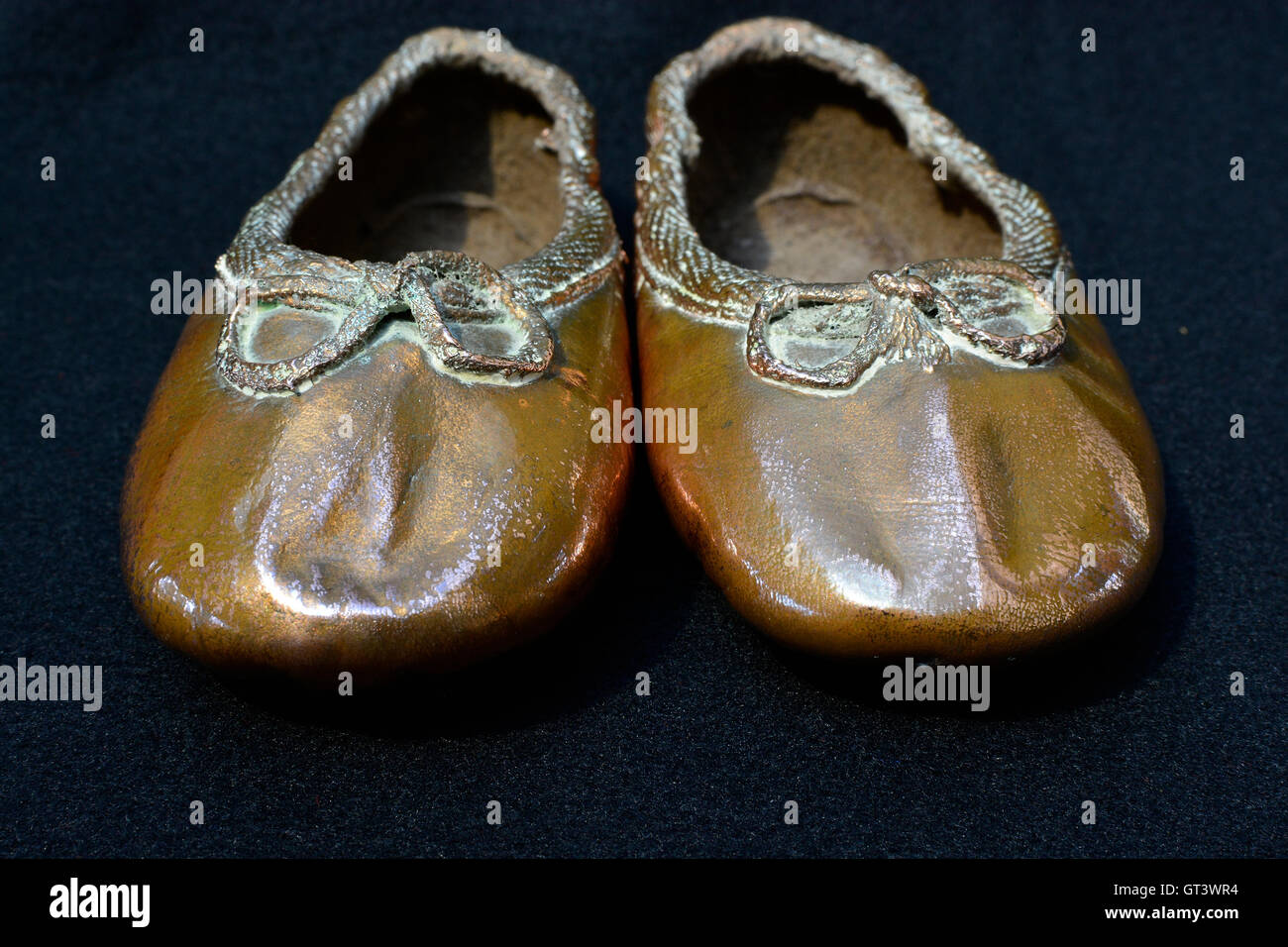 Her first ballet shoes. Copper toddler ballet shoes. Dancing shoes. Baby ballet shoes. Front view. Stock Photo