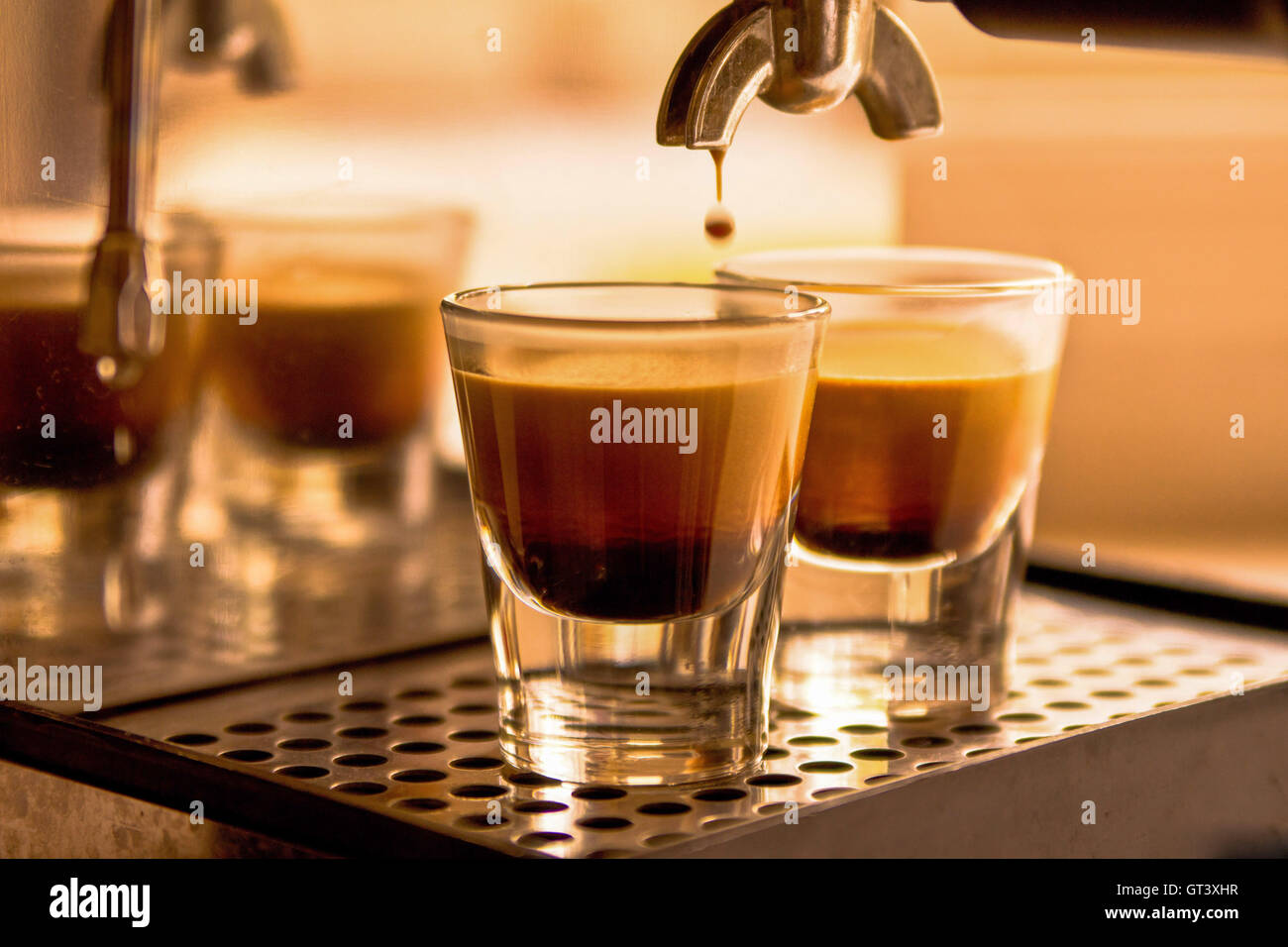 A shot of coffee pouring into two espresso cups Stock Photo Alamy