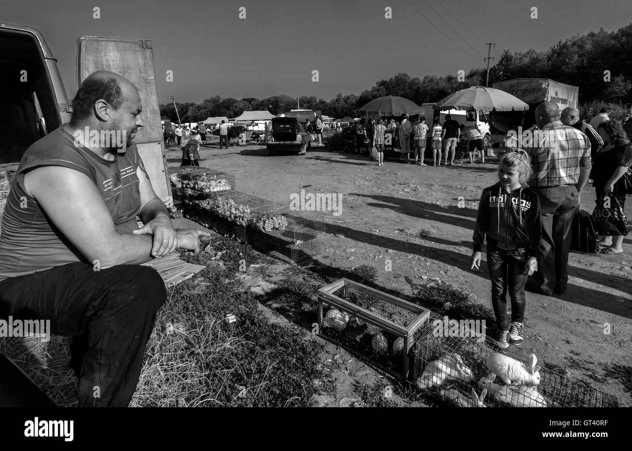 Man who sells rabbits, talking to a little boy on domestic animals market in the town of Kosov, Ivano-Frankivsk Oblast, Ukraine Stock Photo
