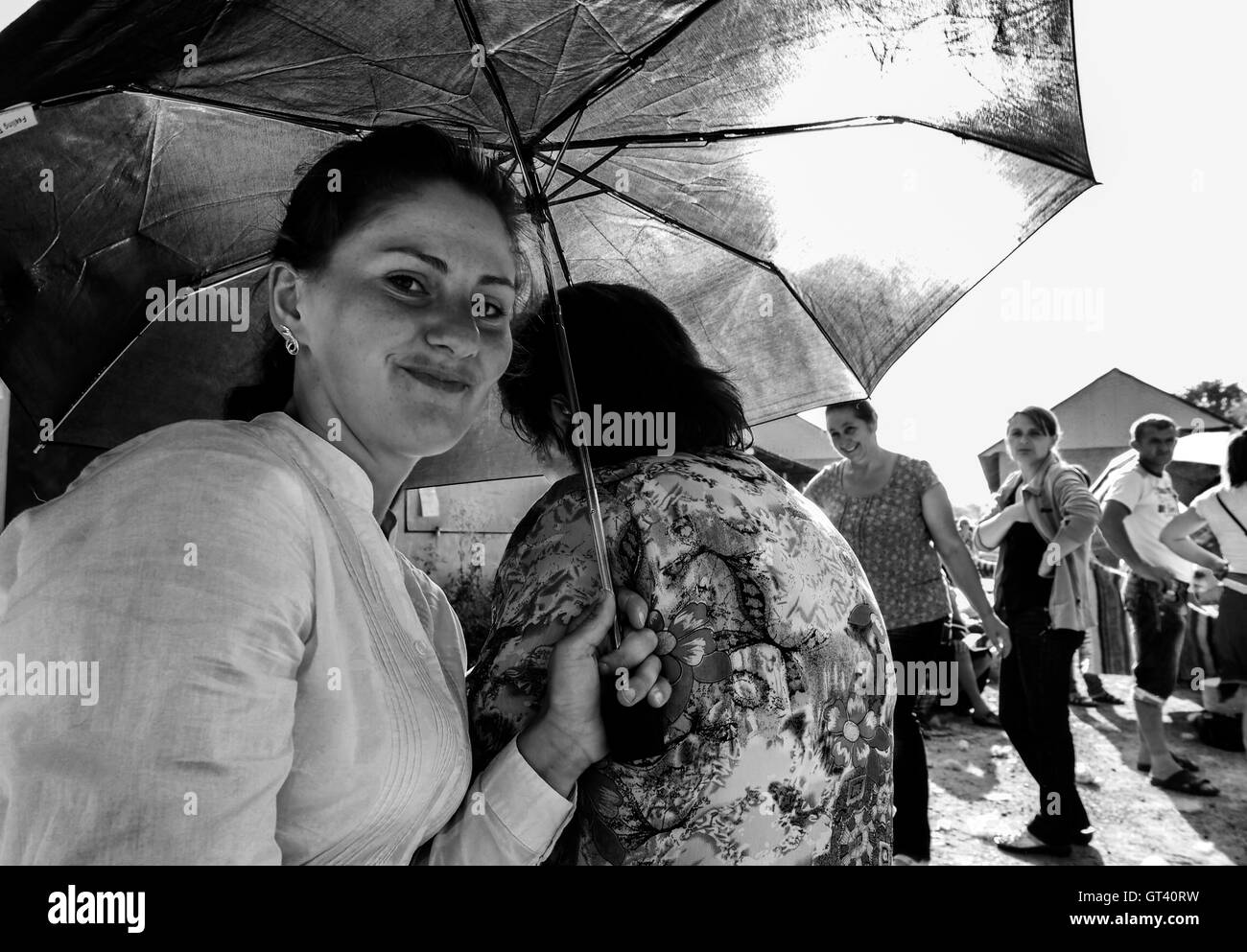 Girl - seller is hiding from the sun under an umbrella on market in the town of Kosov, Ivano-Frankivsk Oblast, Ukraine Stock Photo