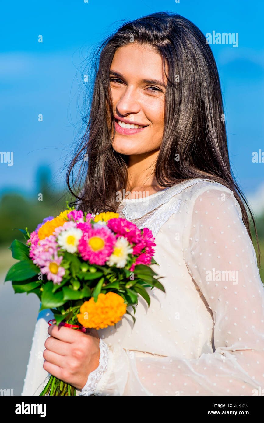 Young women posing outdoors with a bouquet of colorful flowers Stock ...