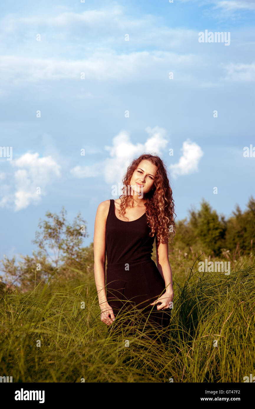 Beautiful girl walks in high grass Stock Photo - Alamy