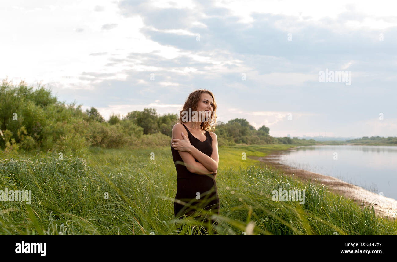 Beautiful girl walks in high grass Stock Photo - Alamy