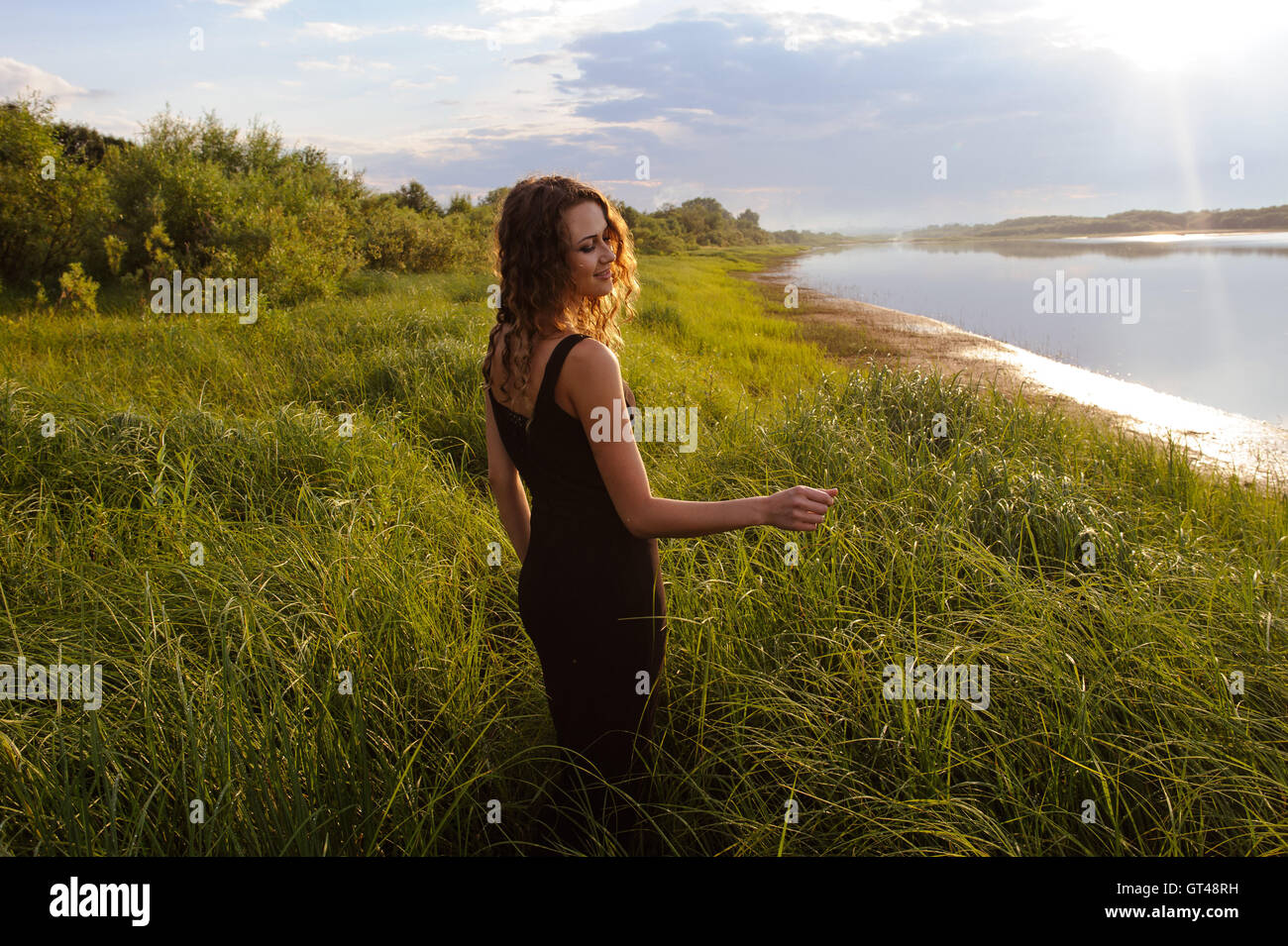 Beautiful girl walks in high grass Stock Photo - Alamy