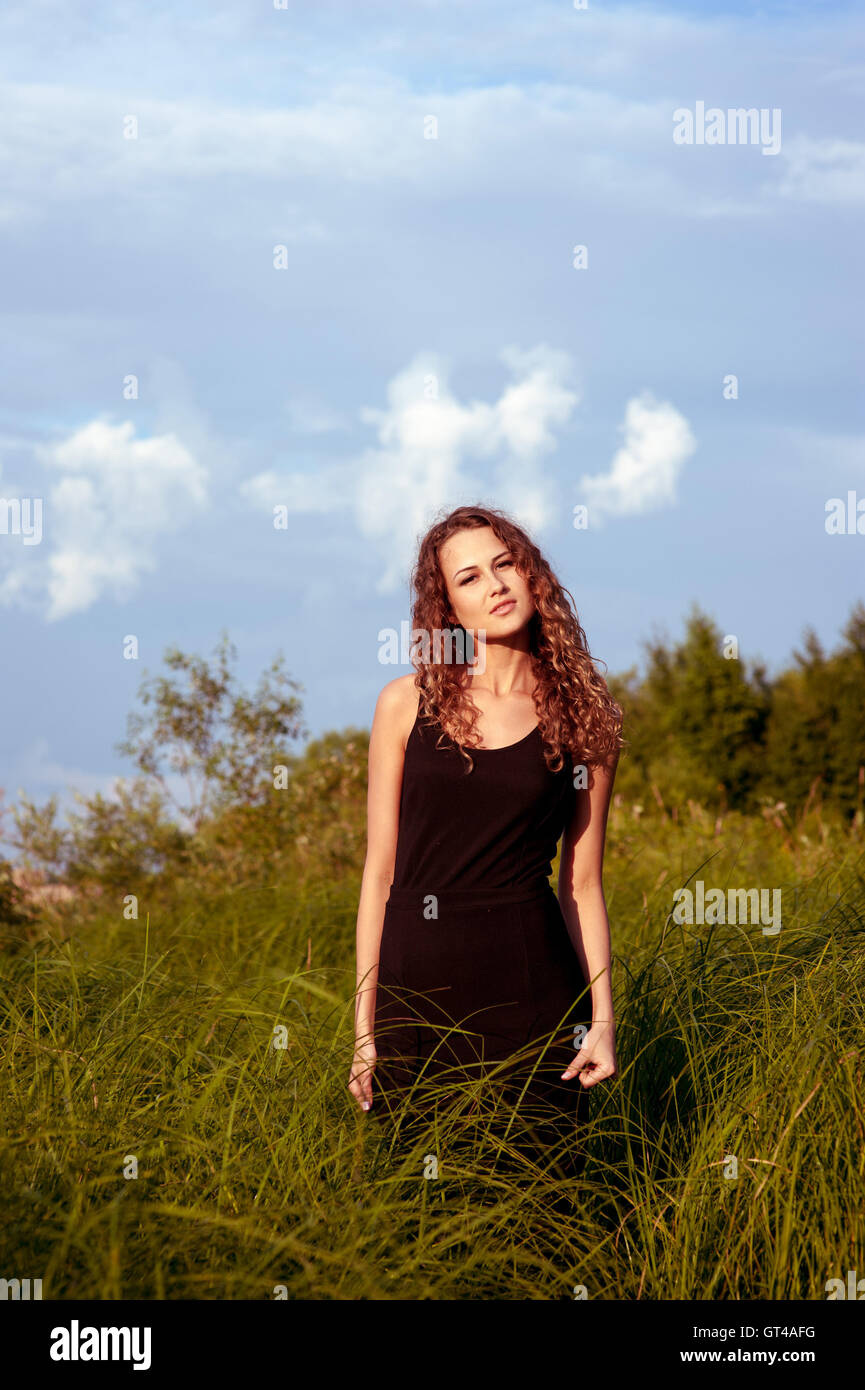 Beautiful girl walks in high grass Stock Photo - Alamy