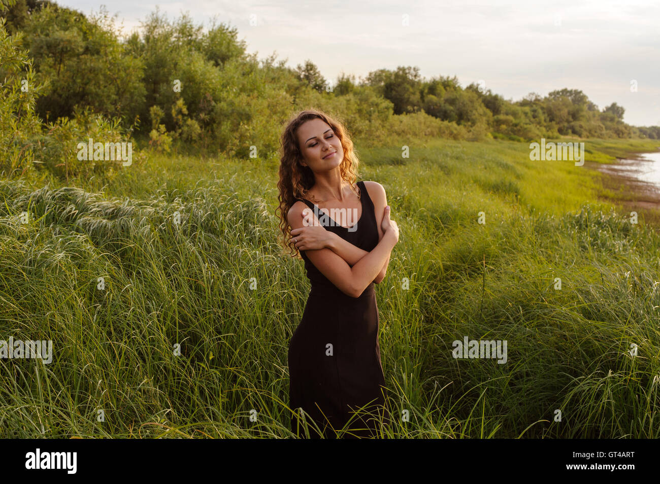 Beautiful girl walks in high grass Stock Photo - Alamy