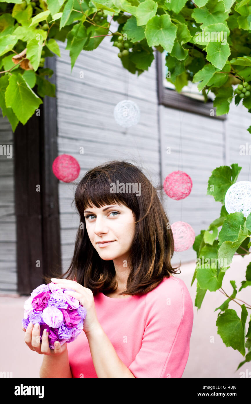 The girl in a pink dress holding a bouquet of purple flowers Stock ...