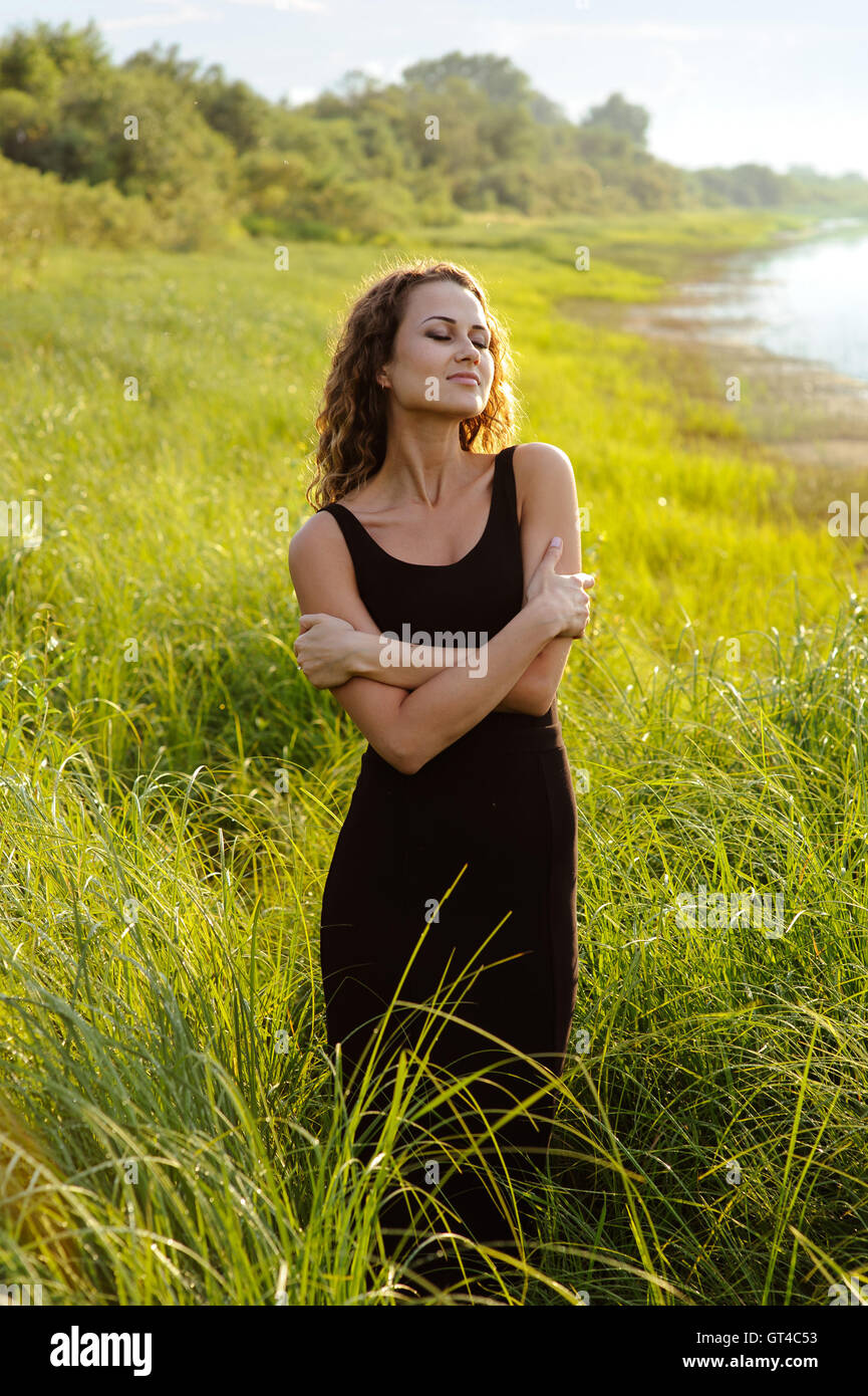 Beautiful girl walks in high grass Stock Photo - Alamy
