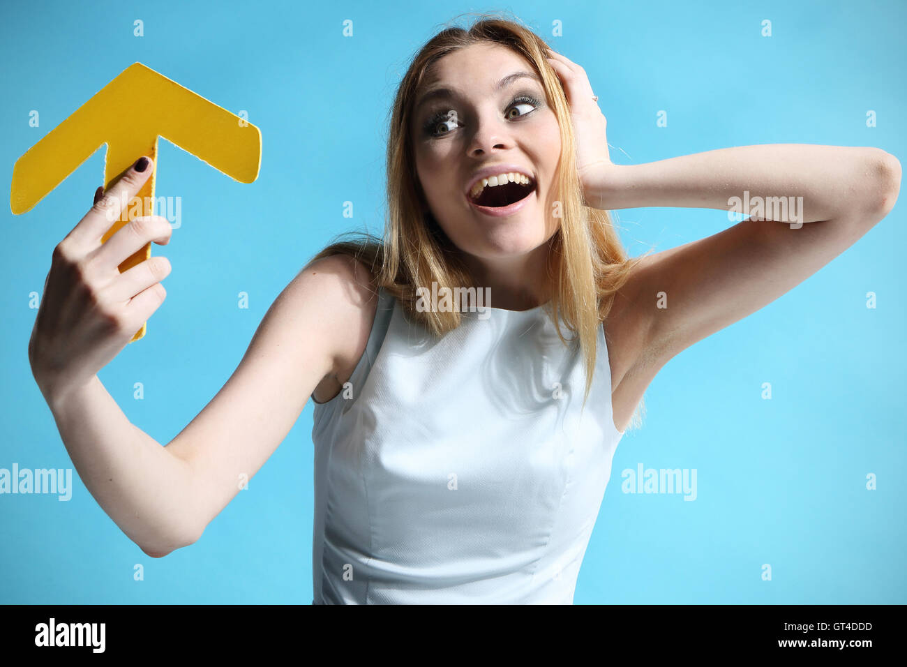 Beautiful girl in a white dress holding an arrow Stock Photo - Alamy