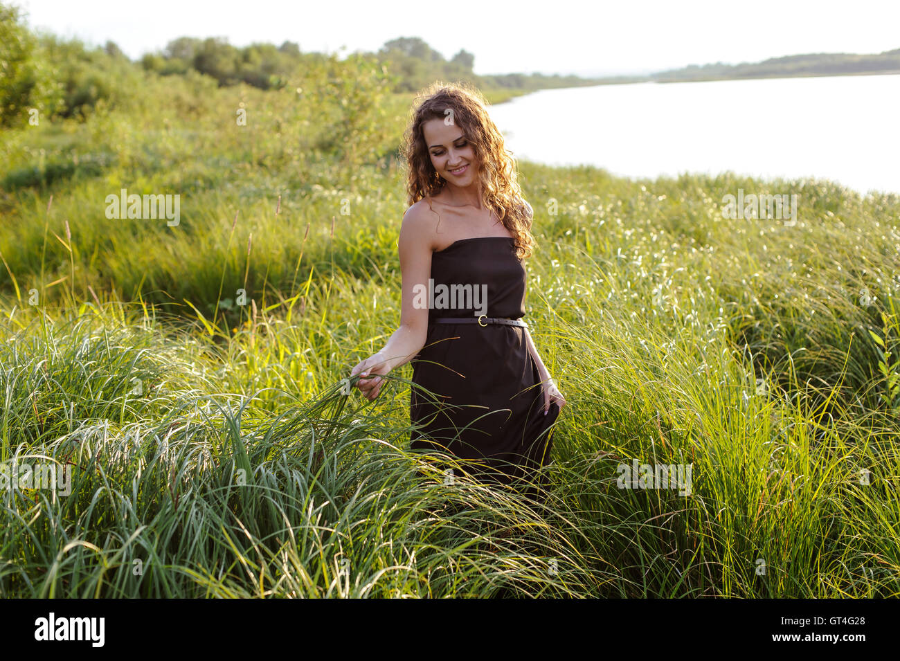 Beautiful girl walks in high grass Stock Photo - Alamy