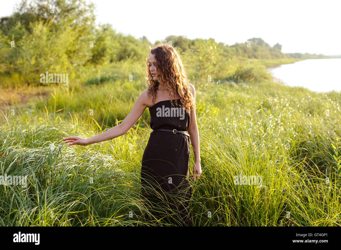 Beautiful girl walks in high grass Stock Photo - Alamy