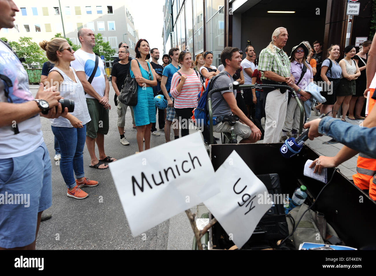 Around 100 participants listen to the London-born and Vienna-based city guide, Eugene Quinn, during the first 'Munich Ugly Tour' in downtown Munich, Germany, 08 September 2016. The city tour visits the ugliest corners of the Bavarian state capital. Photo: ANDREAS GEBERT/dpa Stock Photo