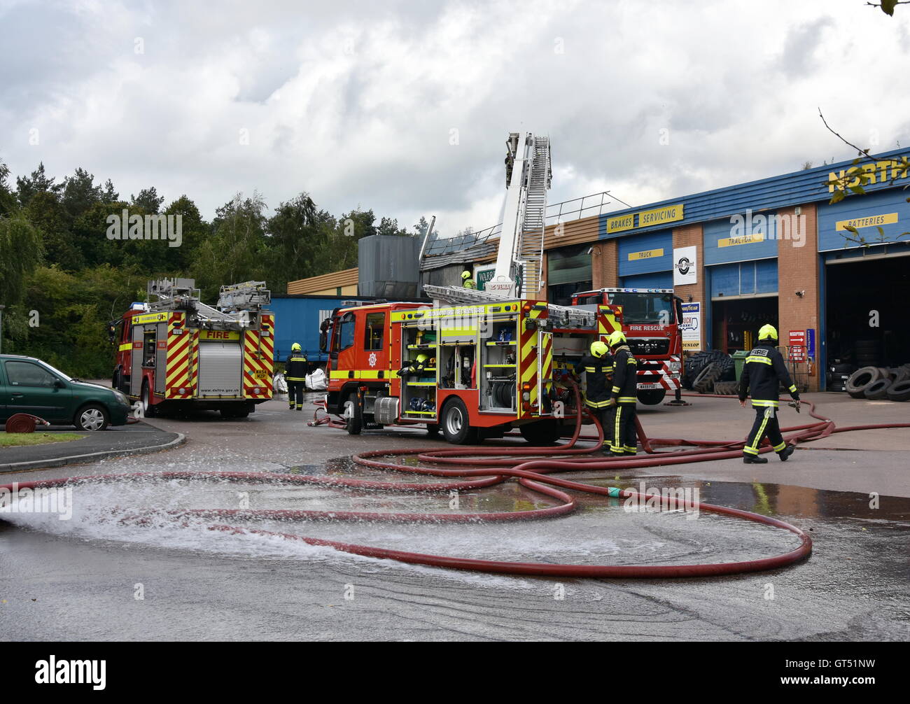 Devon, UK. 9th September, 2016. Tiverton Fire: The scene of a major fire at the premises of Warren Hughes Furniture Makers in Ormidale Square, Tiverton Business Park, Devon, at 16.00 BST on Friday 9th September 2016. The fire brigade were called at 11.23. Five hours later at least 6 fire appliances were still at the scene including two aerial platforms. Staff in the neighbouring units were also evacuated including the premises of North Devon Tyres and National Tyres & Autocare. Credit:  Tim Squires/Alamy Live News Stock Photo