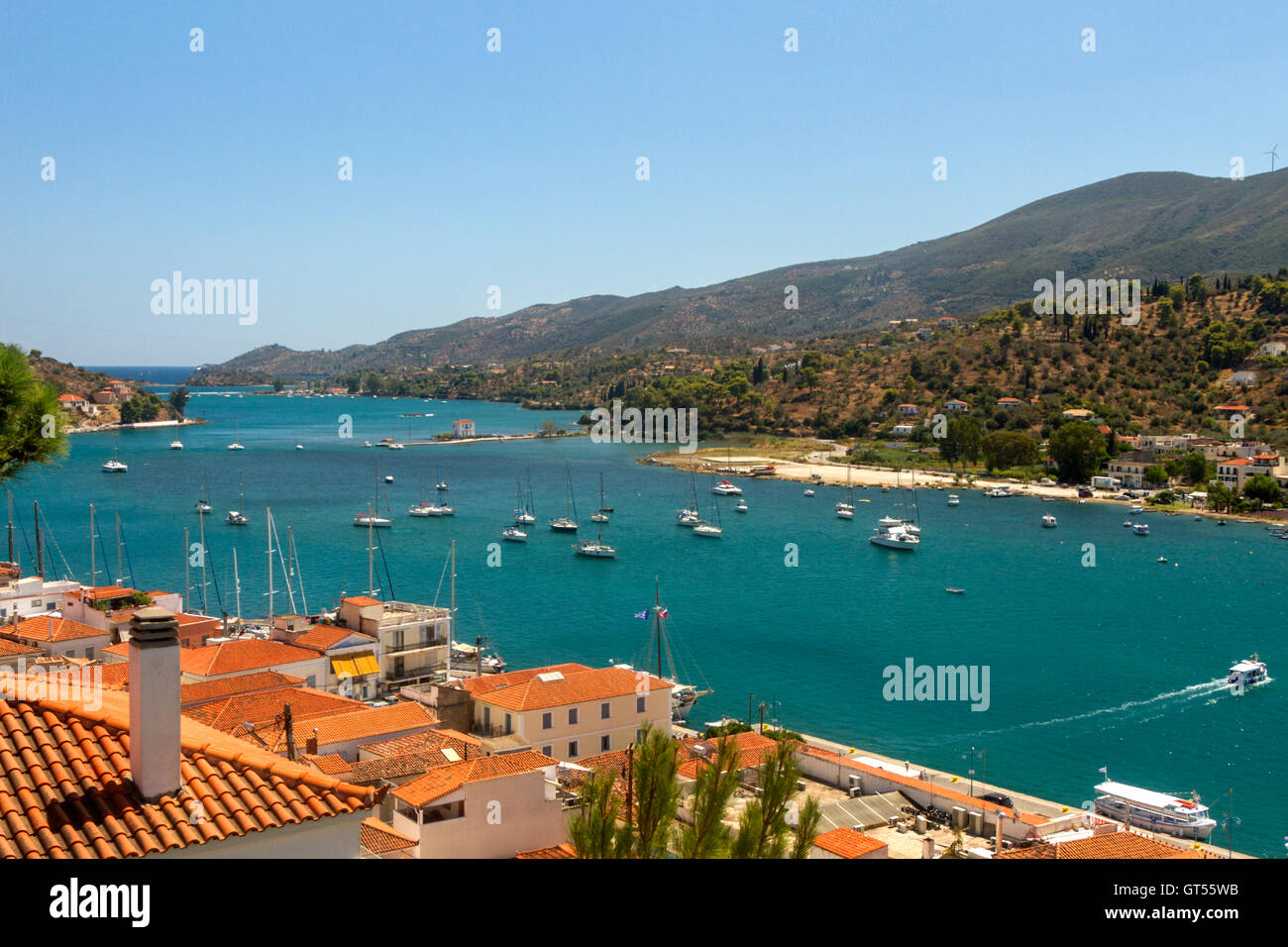 View of Poros town, of Poros island, and of the sea passage full of boats, between Poros island and Trizinia, Peloponnese, Stock Photo