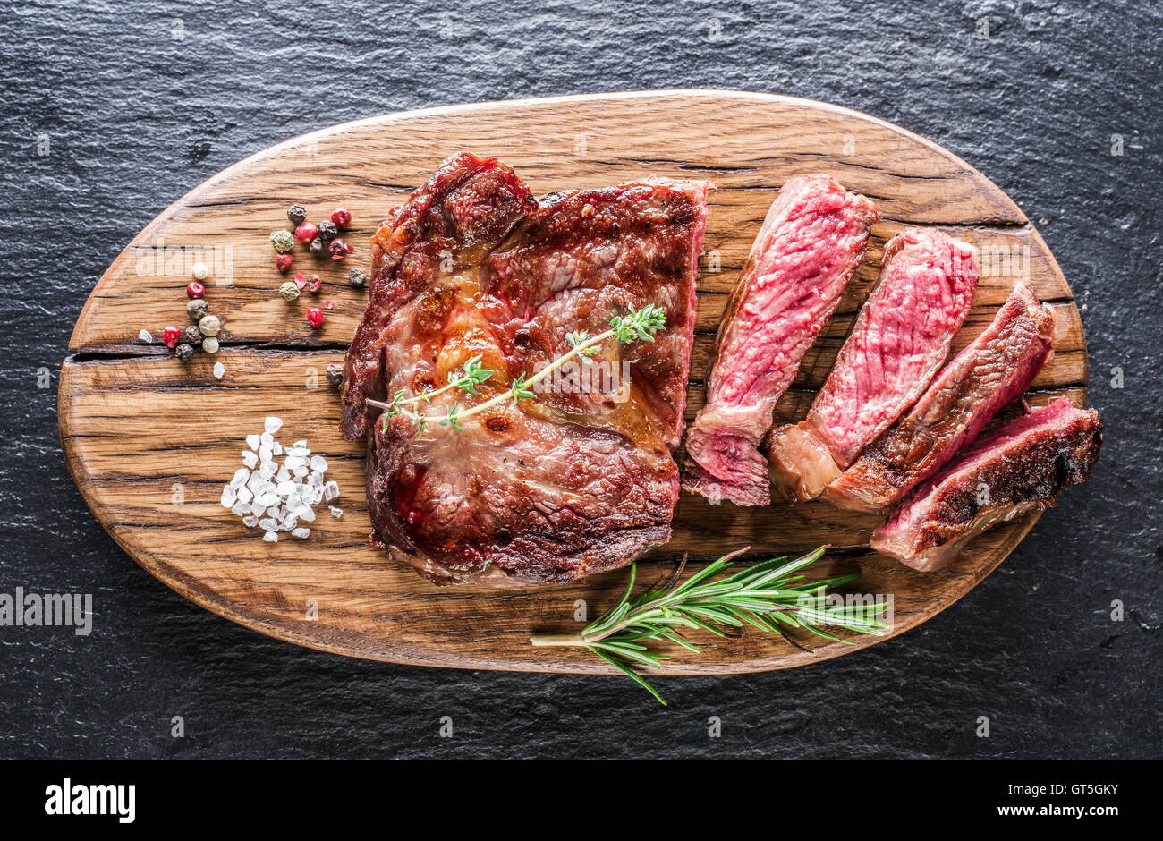 Medium Rib eye steak with spices on the wooden tray Stock Photo - Alamy