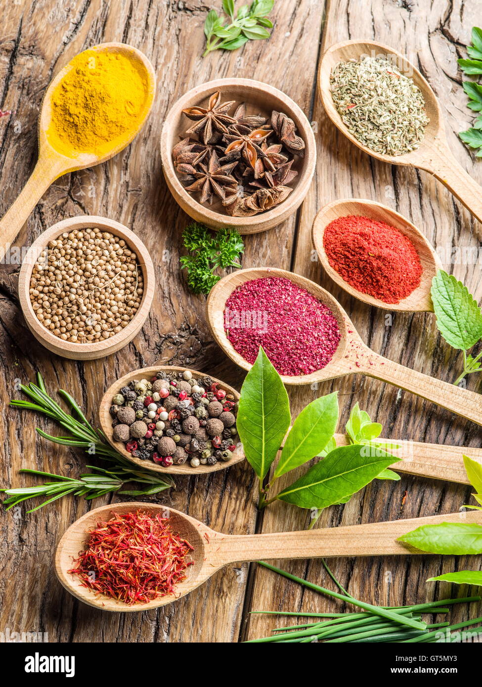 Assortment of colorful spices in the wooden spoons and herbs on the ...