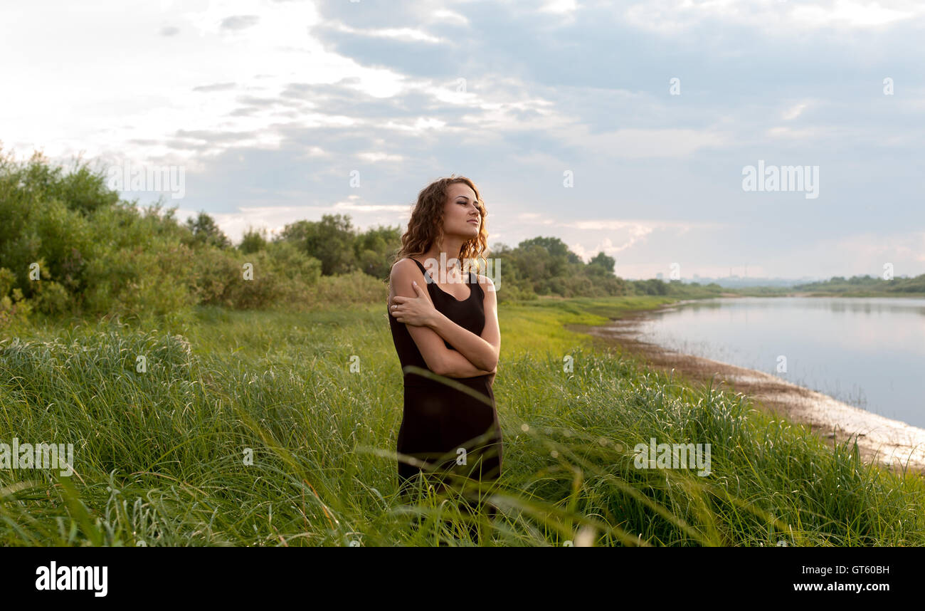 Beautiful girl walks in high grass Stock Photo - Alamy