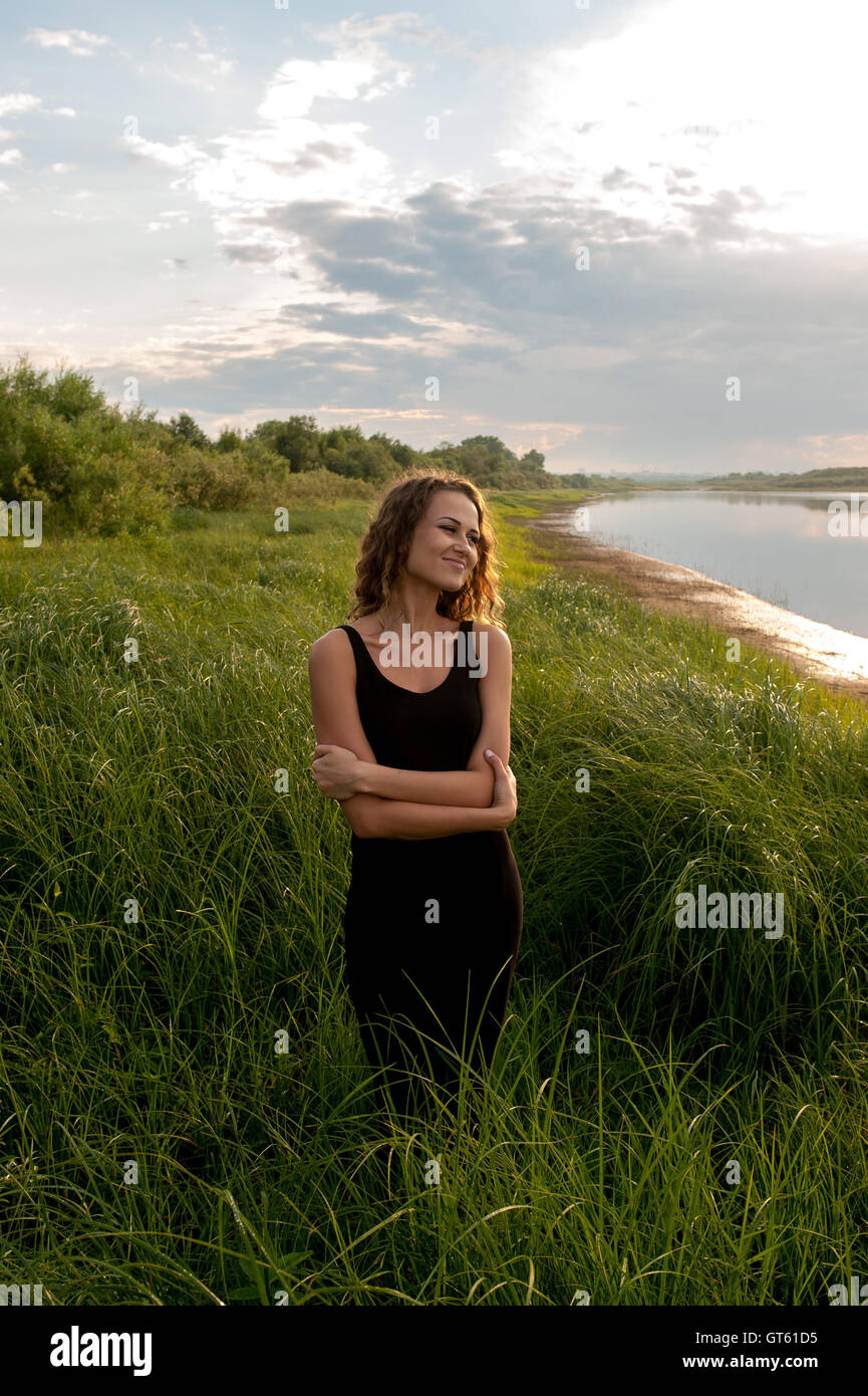 Beautiful girl walks in high grass Stock Photo - Alamy