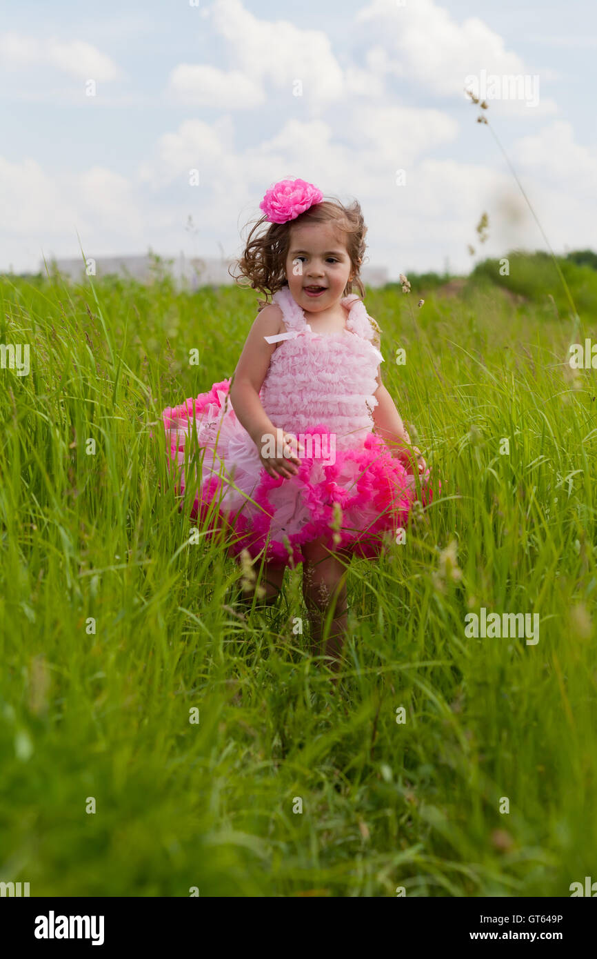 little girl in a pink dress runs on a grass Stock Photo - Alamy