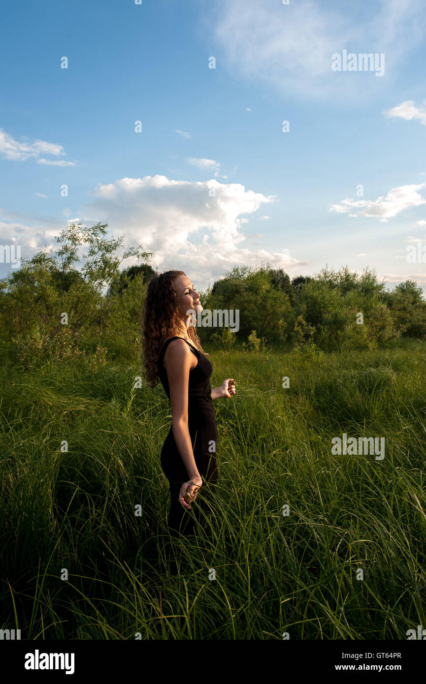 Beautiful girl walks in high grass Stock Photo - Alamy