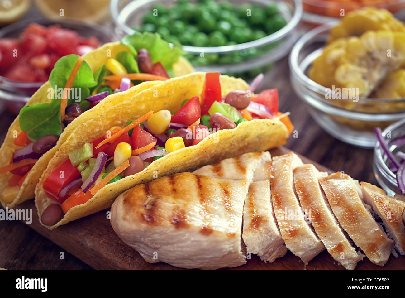 Mexican corn tortilla tacos with vegetables and grilled chicken on
