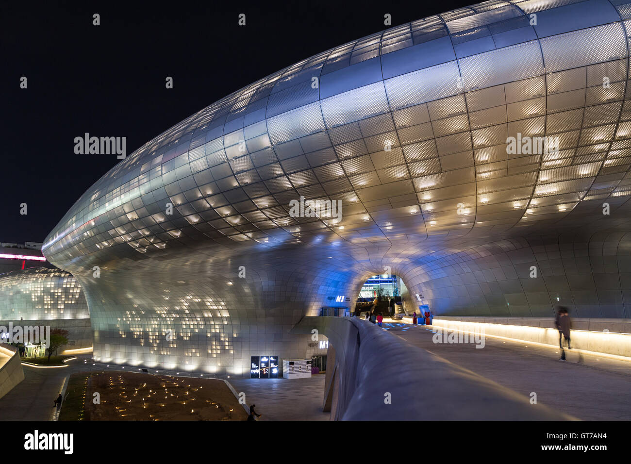 Plaza, bridge and futuristic Dongdaemun Design Plaza (DDP) in Seoul, South Korea at night. Stock Photo