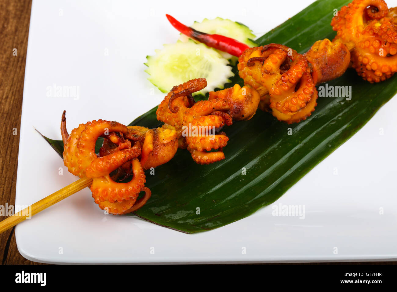 Asian octopus skewer on banana leave with pepper Stock Photo Alamy