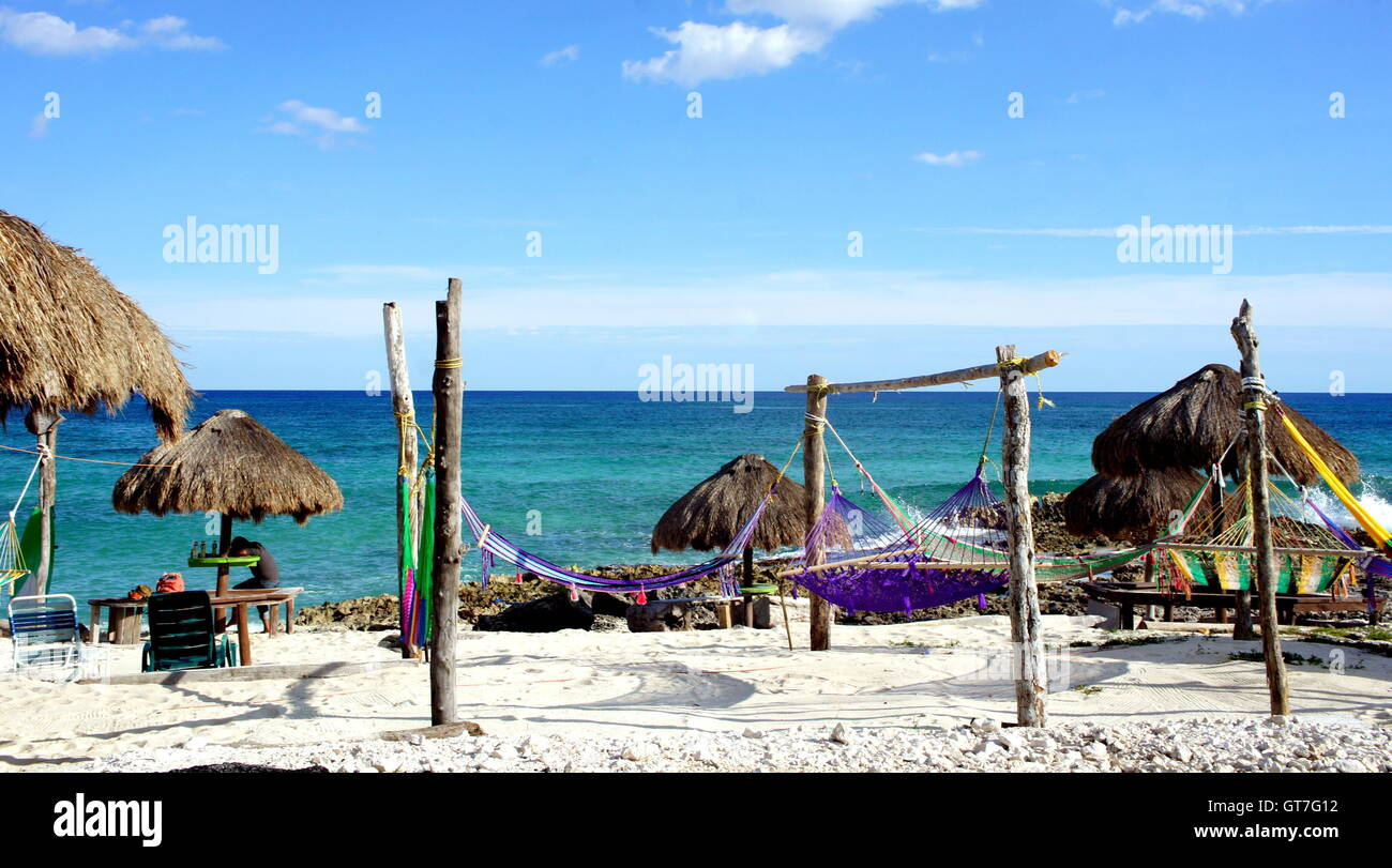 Straw umbrellas and colorful hammocks at an Isla Cozumel beach Stock Photo