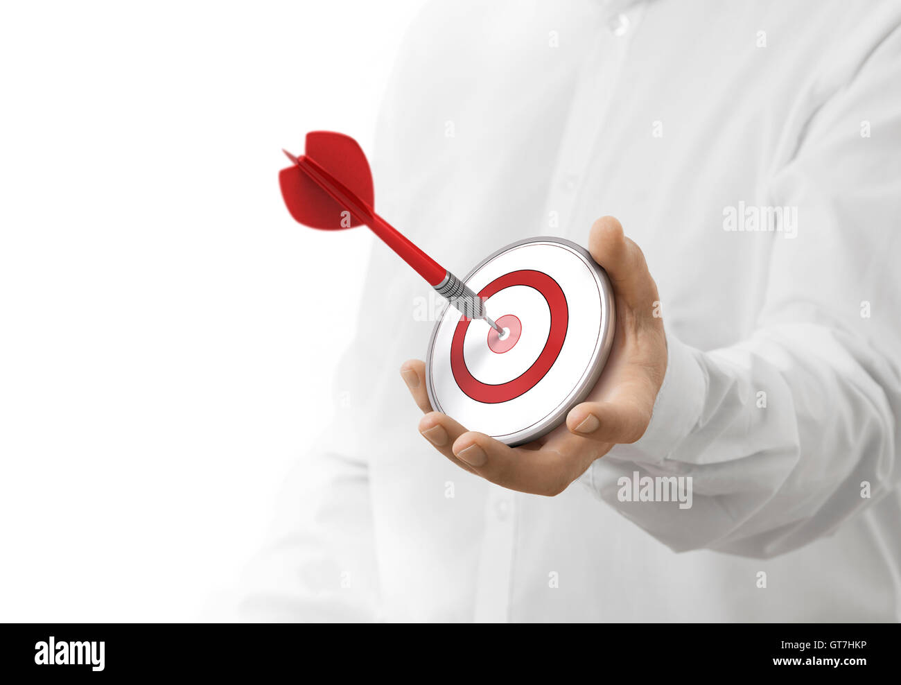 caucasian man holding a modern target with a dart in the center. image over white background. Concept of objective attainment. Stock Photo
