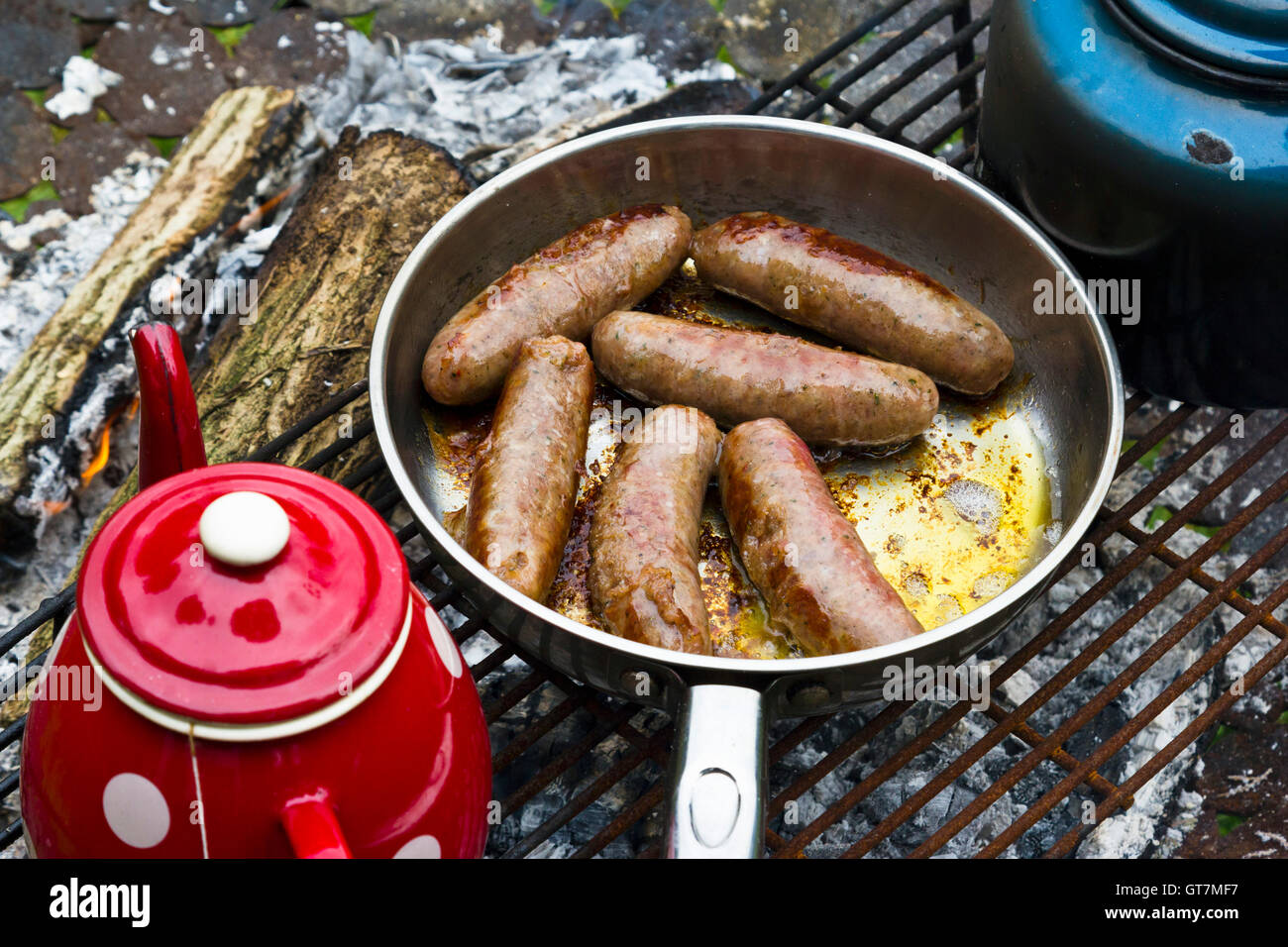 Sausages cooking on a camp fire Stock Photo