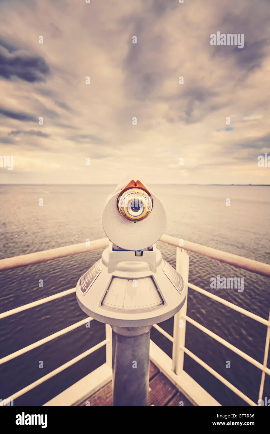 Retro toned picture of a telescope pointed at horizon, shallow depth of field, future concept. Stock Photo