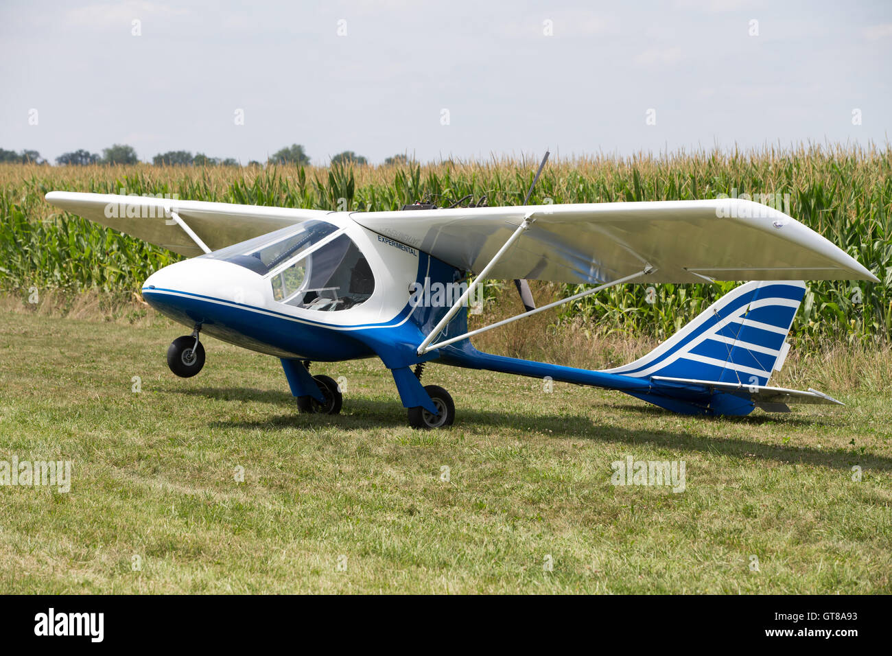 Small little single engine microlight experimental plane sitting in a field balance on its tail with the nose wheel in the air w Stock Photo
