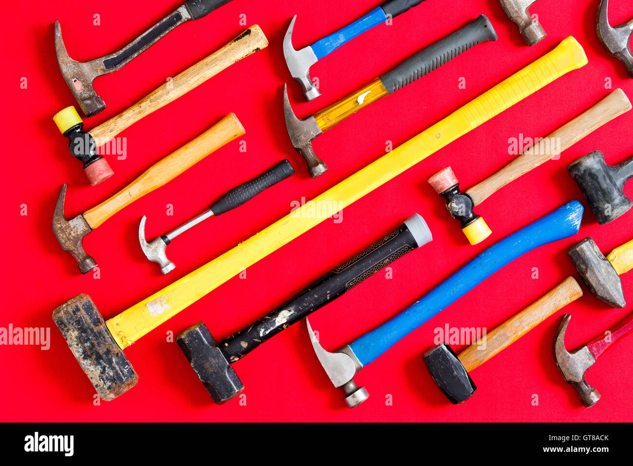 Multiple different mallets and hammers arranged in diagonal lines on a