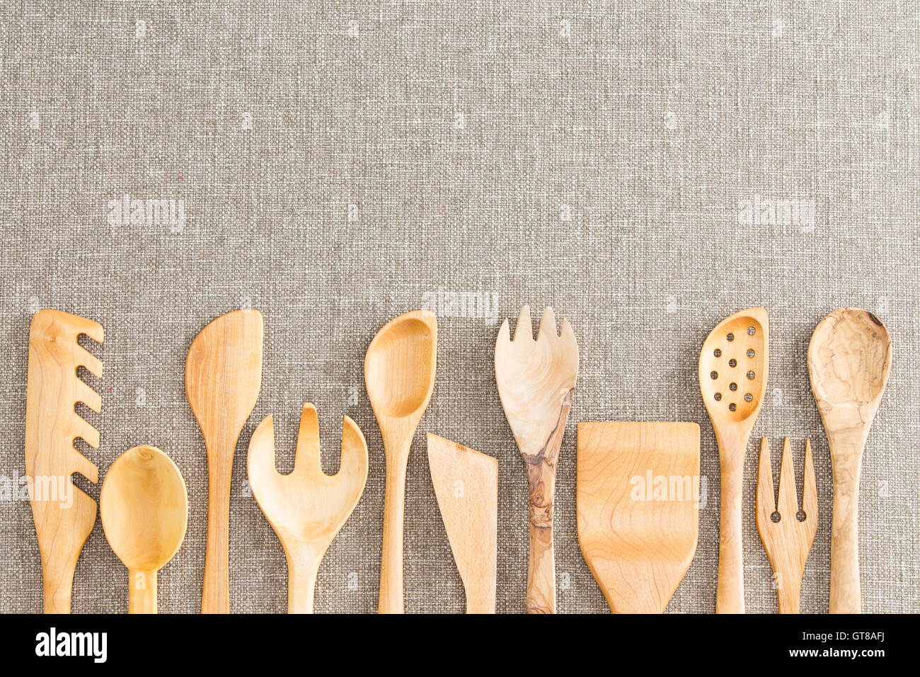 Border of wooden kitchen necessities with the heads of assorted utensils in a row along the