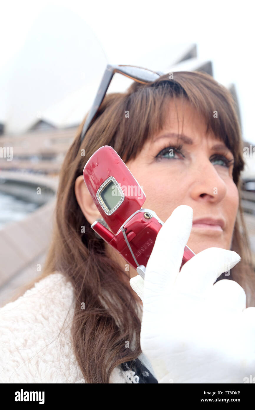 A woman uses Samsung T500 Mobile phone at Sydney Opera house Australia Stock Photo