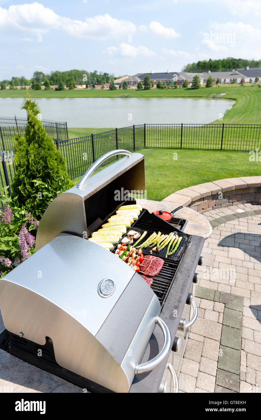 Food arranged ready for grilling on an outdoor gas barbecue in a summer