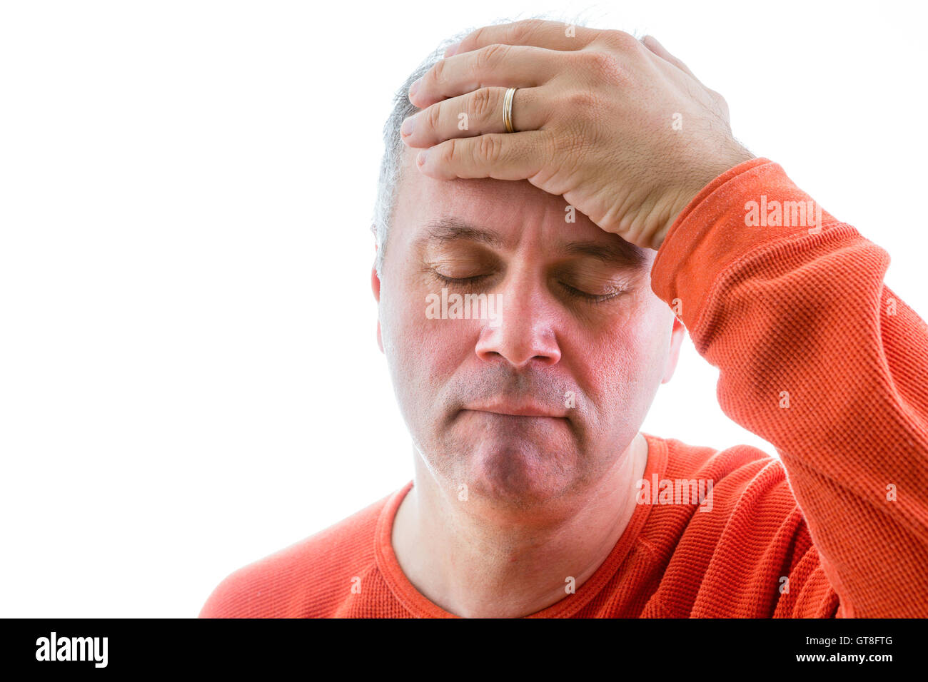 Forgetful man holding his hand to his forehead with a painstaking expression as he struggles to remember something, head and sho Stock Photo