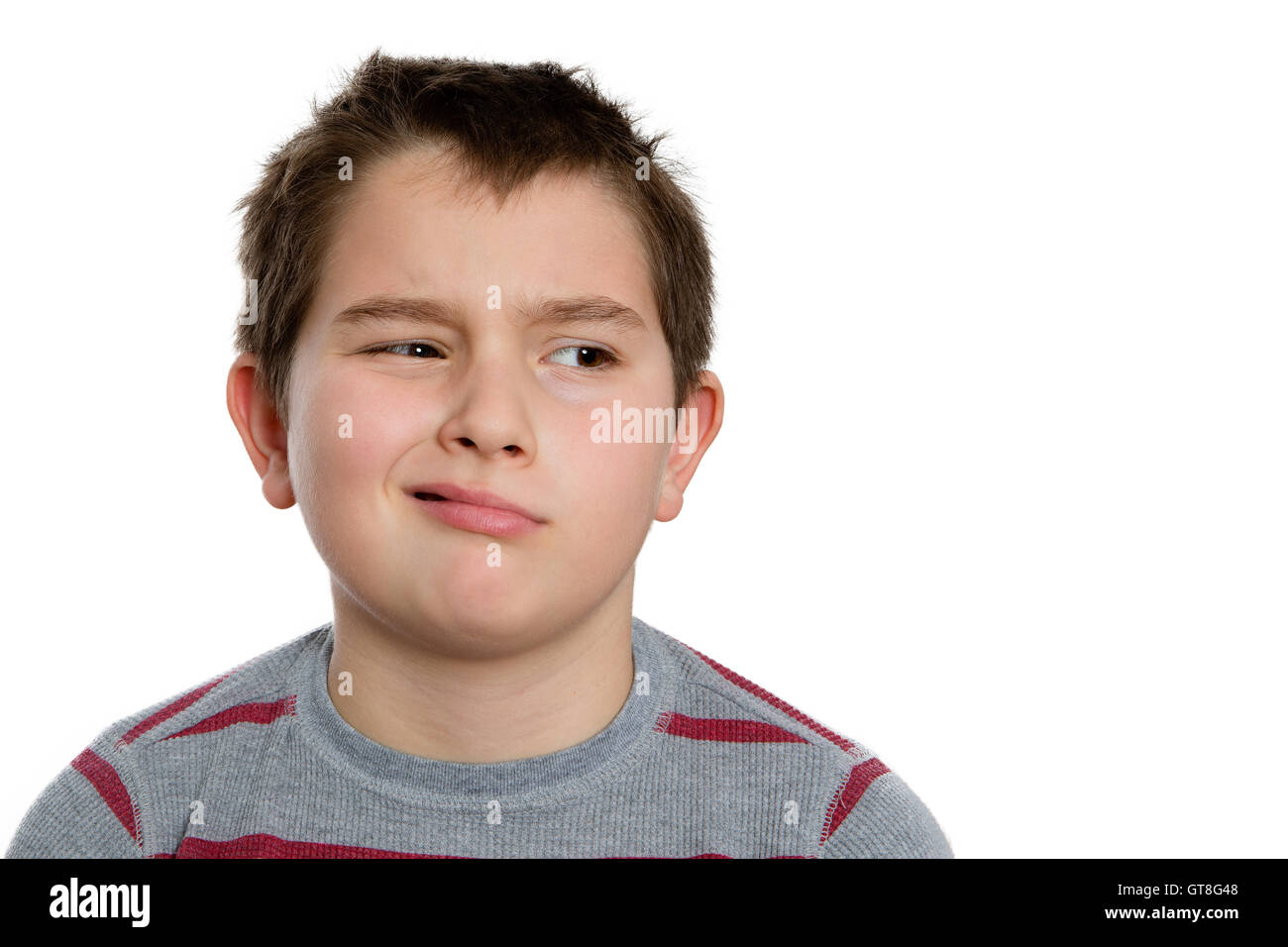 Close up Ten Year Old Boy Looking to the Right with Bored Facial Expression, Isolated on White Background. Stock Photo