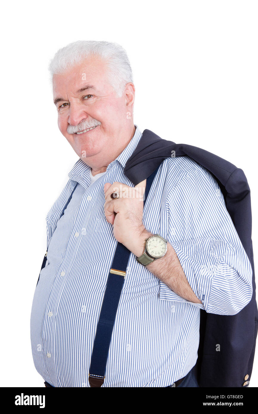 Distinguished white haired retired gentleman with his suit jacket slung over his shoulders and wearing suspenders smiling happil Stock Photo