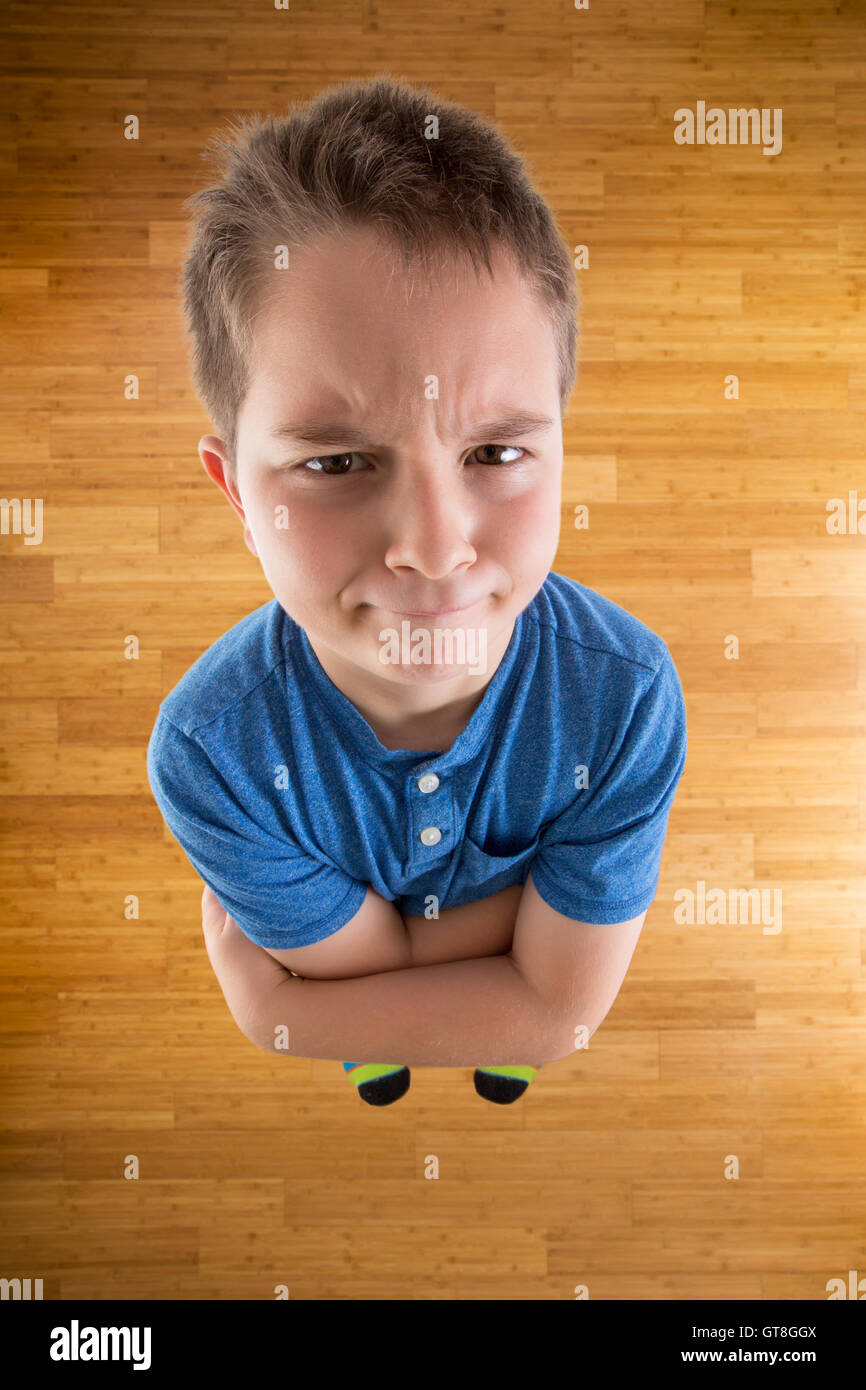Cute Young Boy Demanding What he Wants While Looking at the Camera from High Angle View with Arms Crossing Over his Chest. Stock Photo