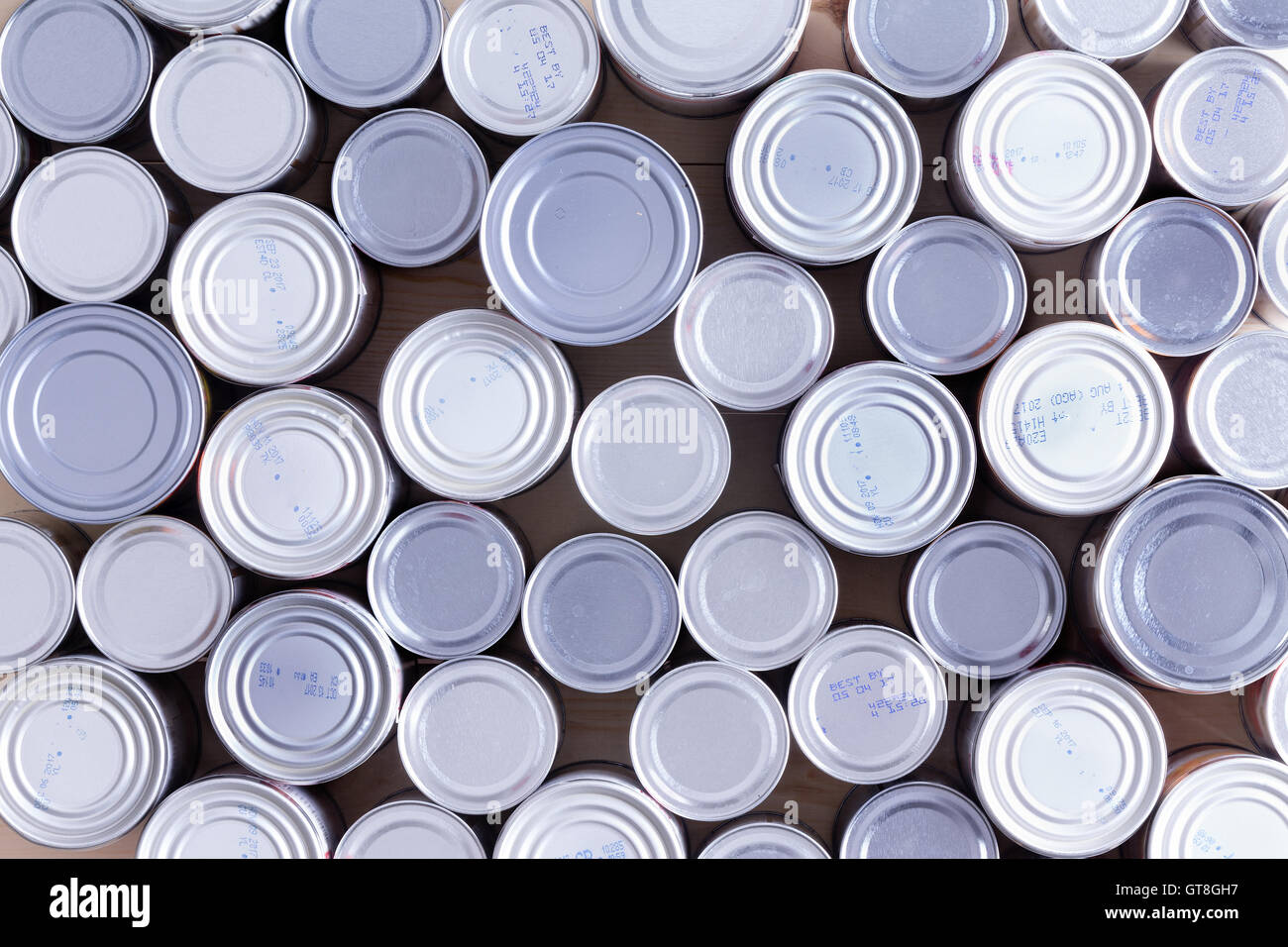 Background of multiple sealed food cans or tins viewed from overhead in