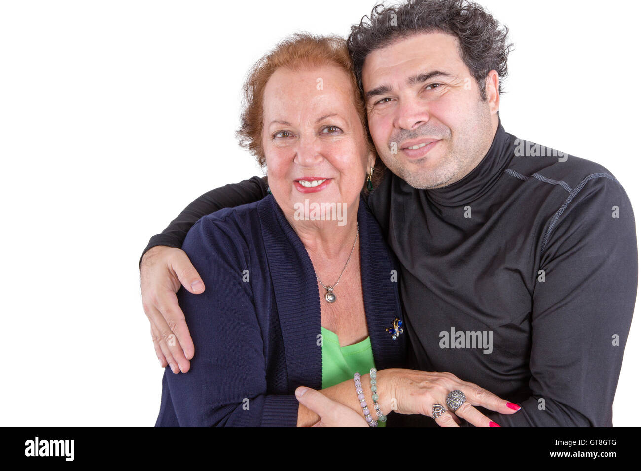 Mother and son sharing a tender moment as they hug each other affectionately with an elderly stylish lady and attractive curly h Stock Photo