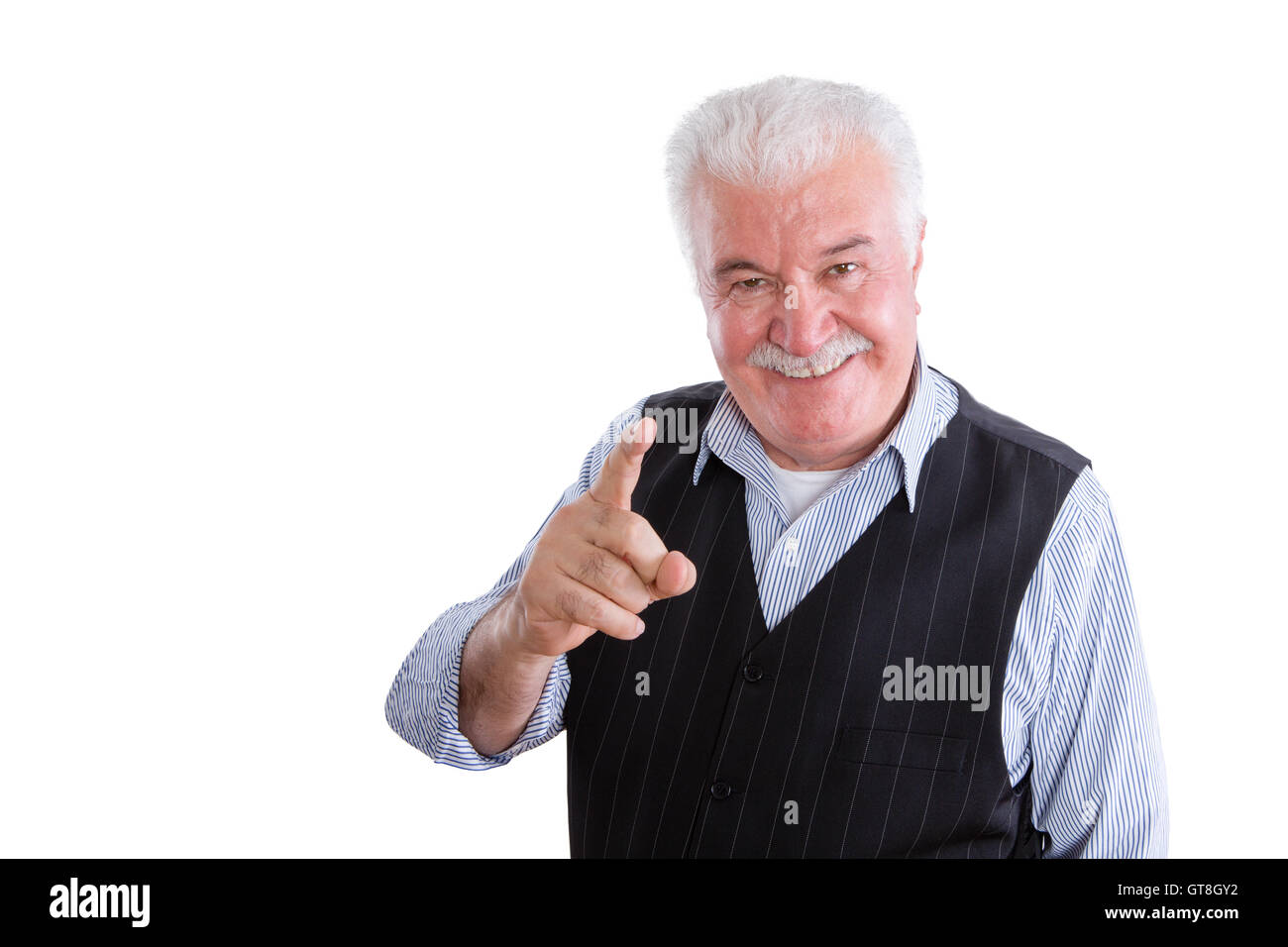 Pleased handsome male pensioner in vest with mustache on isolated background conversing and pointing finger Stock Photo
