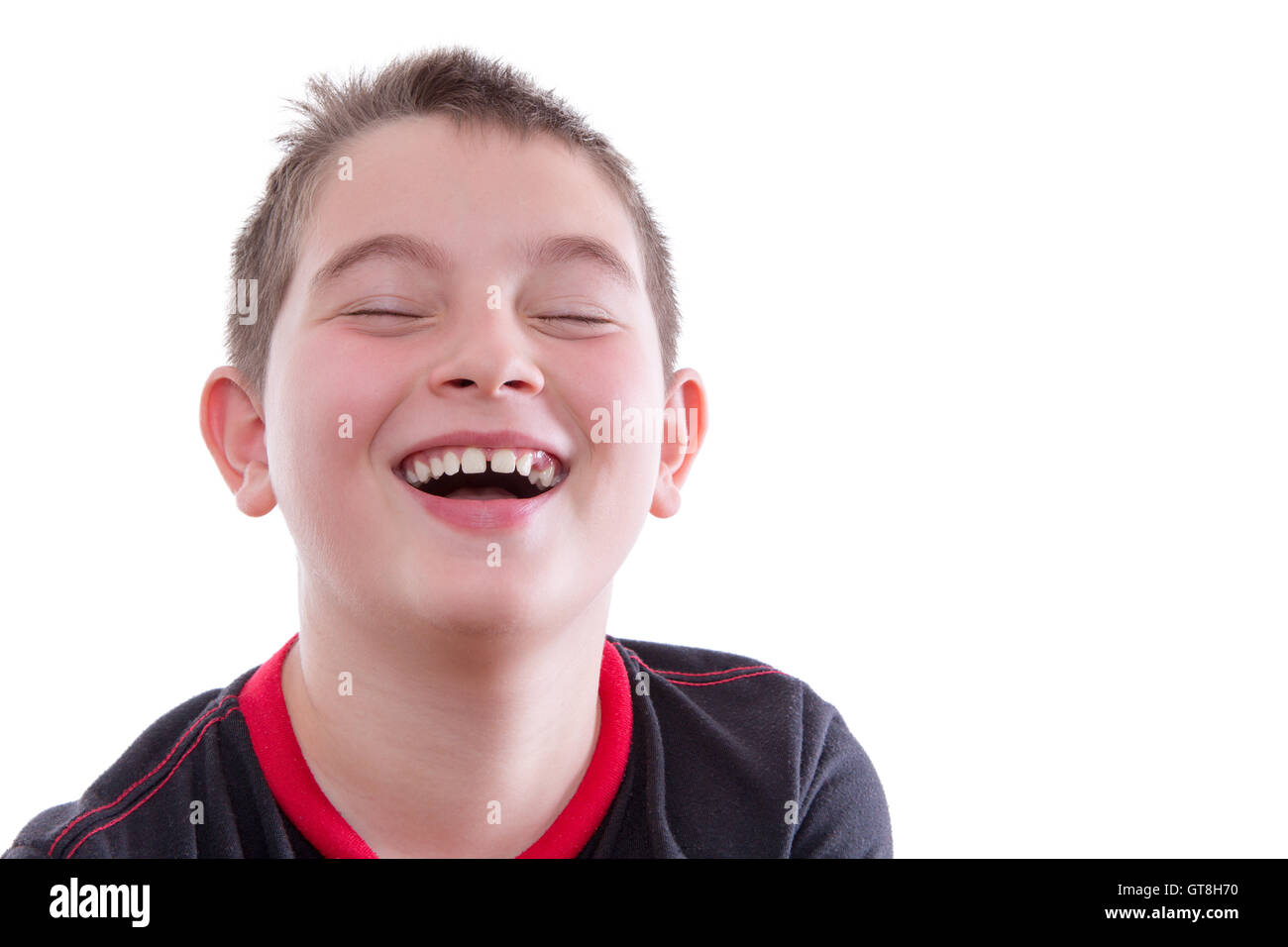 Head and Shoulders Close Up Portrait of Joyful Young Boy Wearing Red and Black T-Shirt and Laughing with Eyes Closed in Studio w Stock Photo