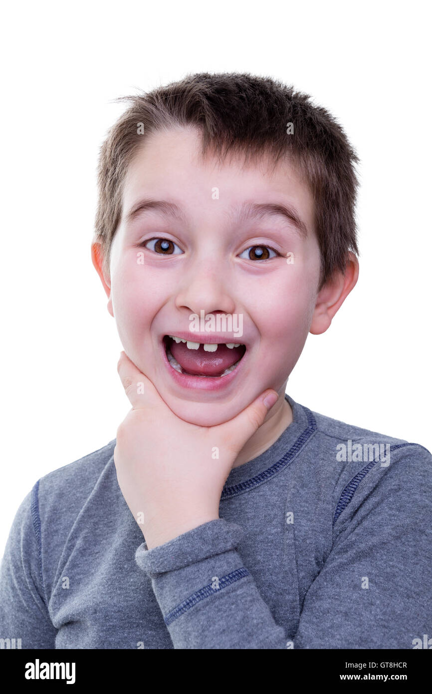 Cute little boy in gray shirt holding his chin with wide open mouth and big smile over white background Stock Photo