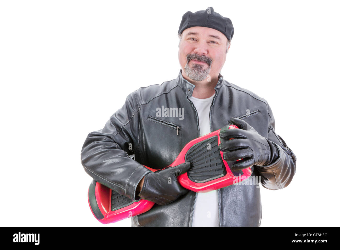 Content middle aged handsome man in hat and leather jacket stands holding a red and black hoverboard in hands with leather glove Stock Photo