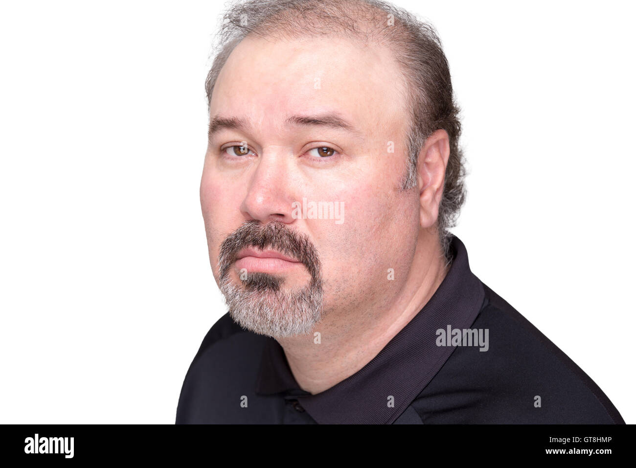 Close up of downcast middle aged male in black shirt with graying beard and mustache over white background Stock Photo