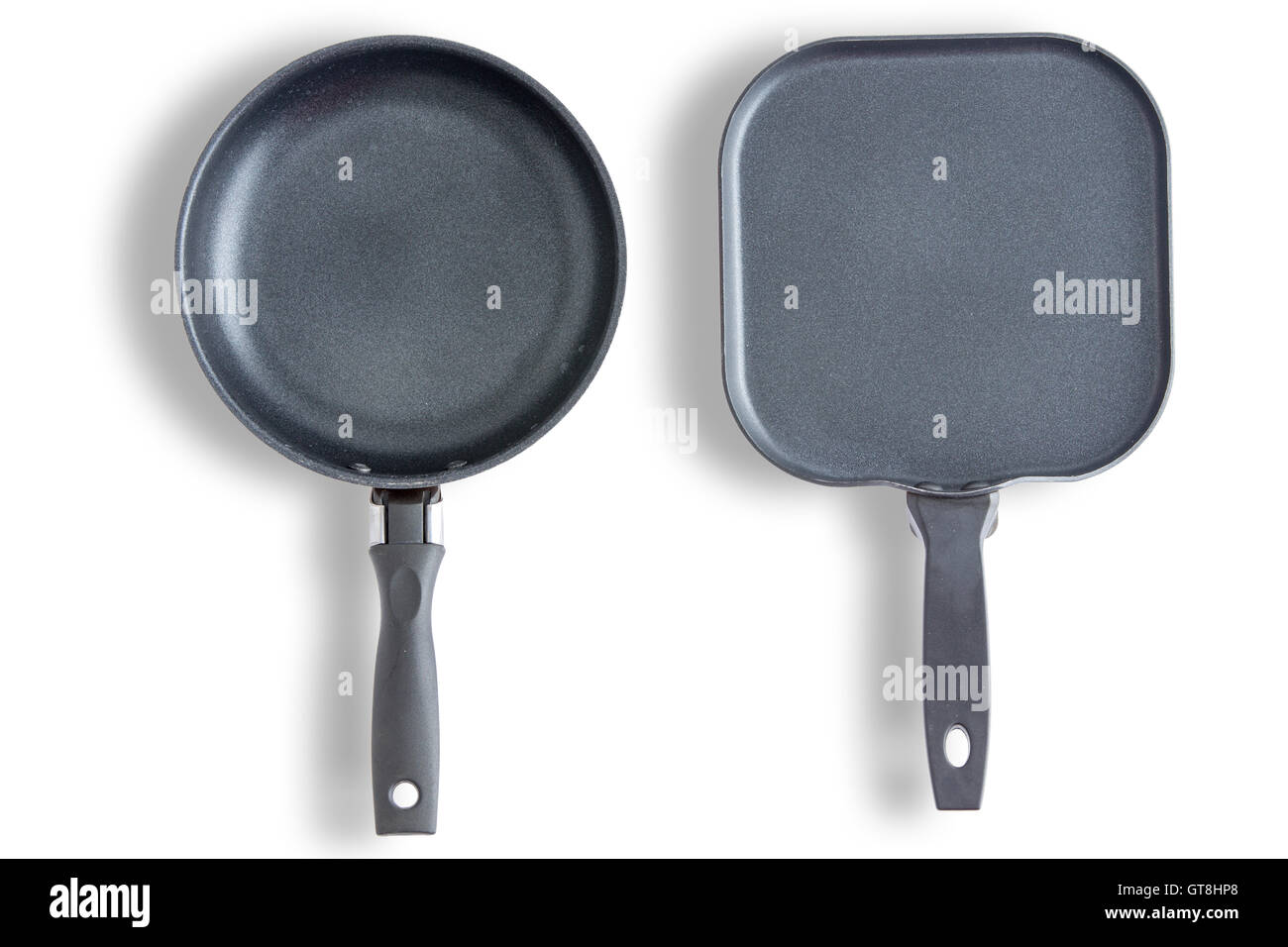 Two round and square with chamfered corners clean pans or skillets on a white background arranged side by side and viewed from a Stock Photo