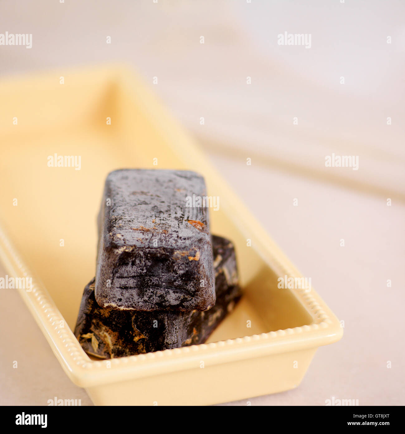 Two Artisanal Bars of Soap Stacked in Yellow Soap Dish Stock Photo