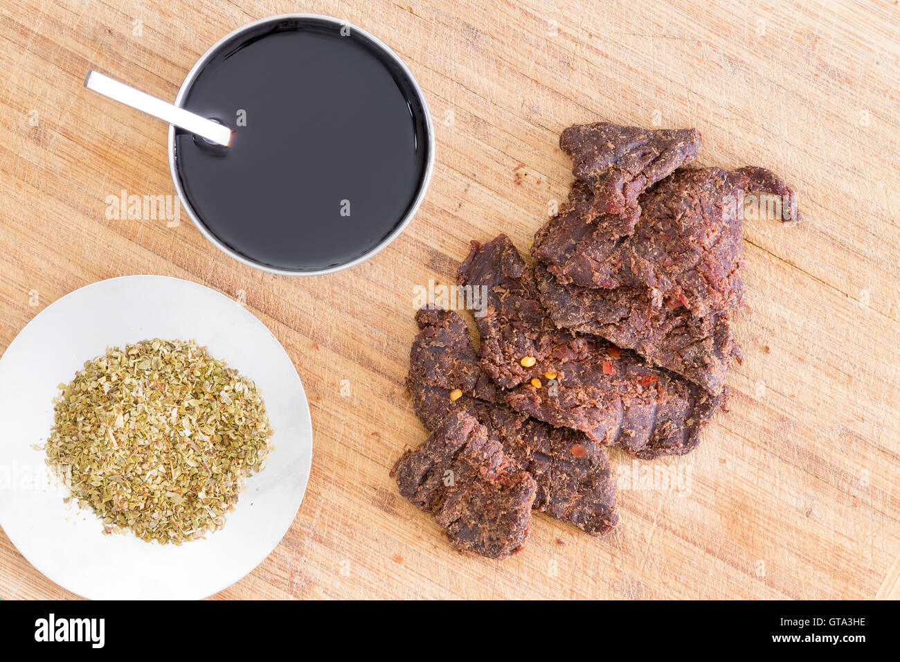 Preparing beef jerky for drying with strips of lean beef, dried oregano